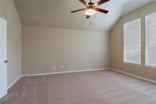 spare room with lofted ceiling, light colored carpet, and ceiling fan