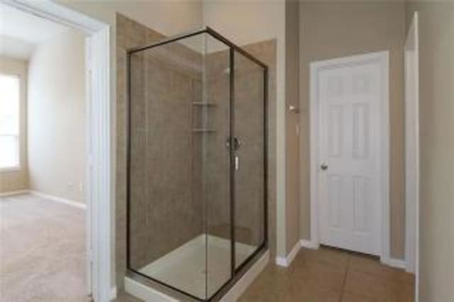 bathroom with tile patterned flooring and a shower with door