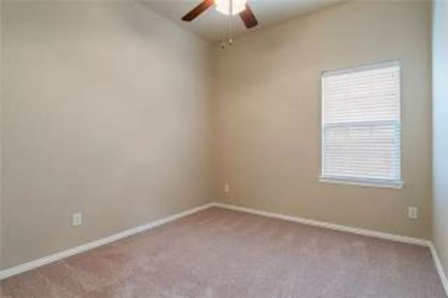 empty room with ceiling fan and light carpet