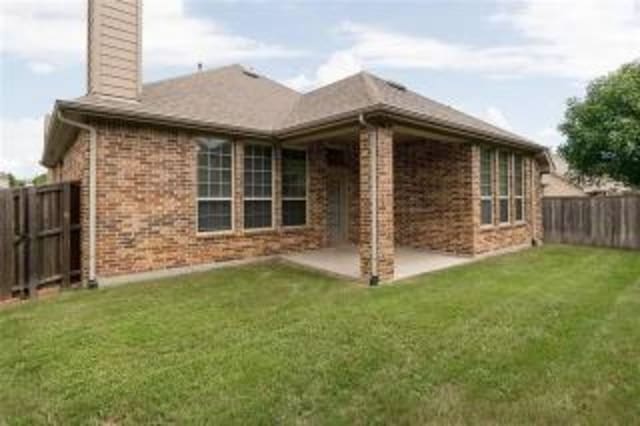 rear view of property with a patio area and a lawn