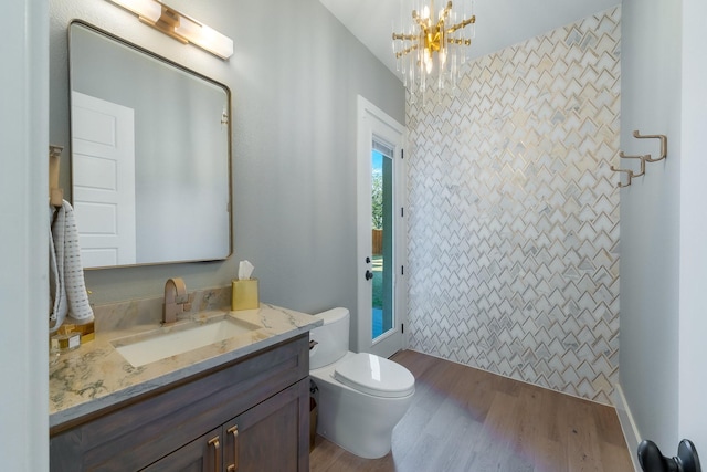 full bath with a shower with curtain, toilet, a notable chandelier, wood finished floors, and vanity