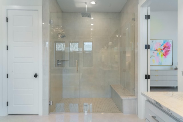 bathroom featuring vanity and a shower with door