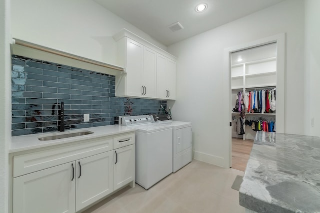 laundry room featuring visible vents, a sink, washing machine and dryer, recessed lighting, and cabinet space