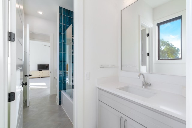 bathroom with vanity, parquet flooring, and combined bath / shower with glass door