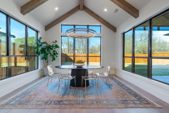 sunroom featuring lofted ceiling with beams, visible vents, and a chandelier