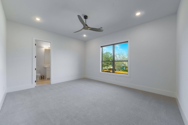 unfurnished bedroom featuring connected bathroom, light colored carpet, and ceiling fan