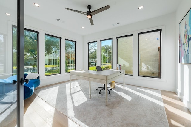 home office with ceiling fan and light hardwood / wood-style floors