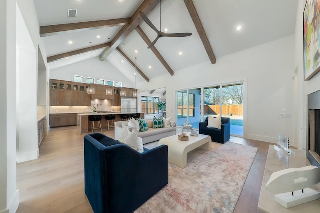 living room with beamed ceiling, ceiling fan, high vaulted ceiling, and light hardwood / wood-style floors