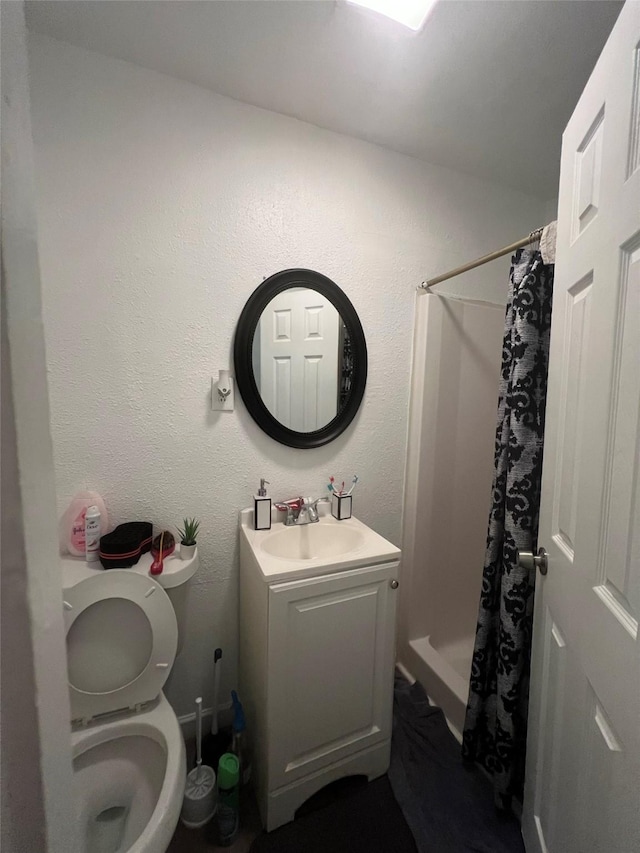 bathroom featuring a shower with curtain, toilet, and vanity