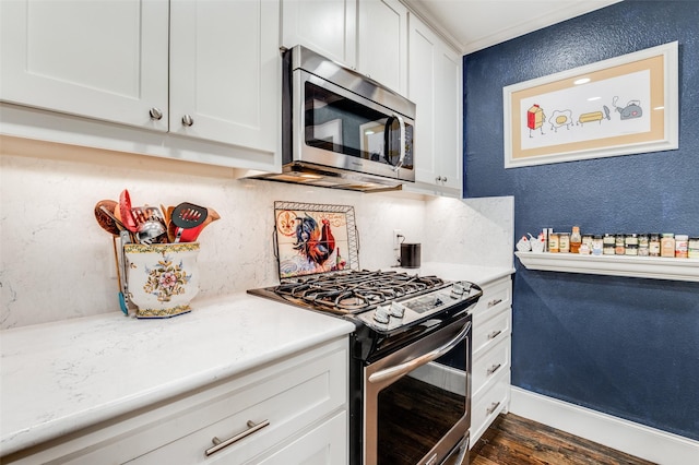 kitchen with white cabinets, stainless steel appliances, and dark hardwood / wood-style floors