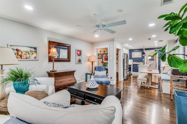 living room with ceiling fan, dark wood-type flooring, and ornamental molding