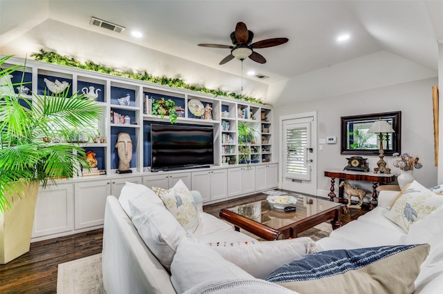 living room with dark hardwood / wood-style flooring, a raised ceiling, and ceiling fan