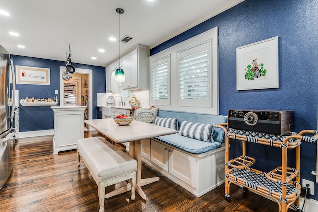 dining room featuring breakfast area, dark hardwood / wood-style flooring, and crown molding