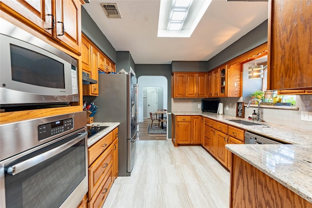 kitchen with appliances with stainless steel finishes, decorative light fixtures, sink, and backsplash