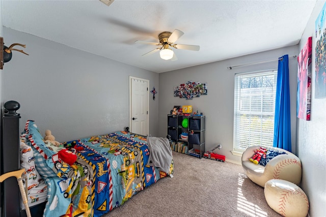 carpeted bedroom with ceiling fan and a textured ceiling