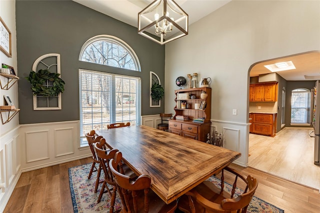 dining space with light hardwood / wood-style flooring and a chandelier