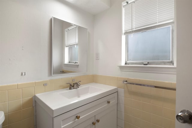 bathroom with vanity and tile walls