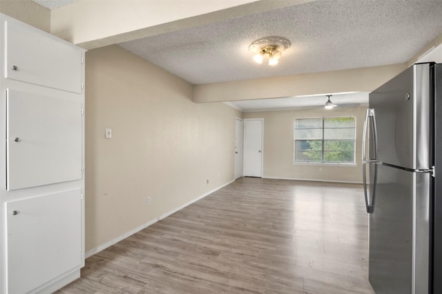 interior space with a textured ceiling and light hardwood / wood-style floors