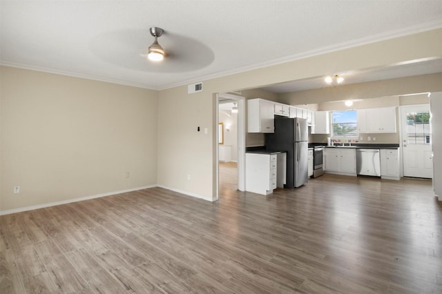 unfurnished living room featuring dark hardwood / wood-style flooring, ceiling fan, and ornamental molding