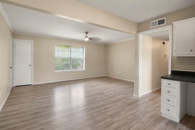 unfurnished living room featuring light wood-type flooring, a textured ceiling, ceiling fan, and crown molding