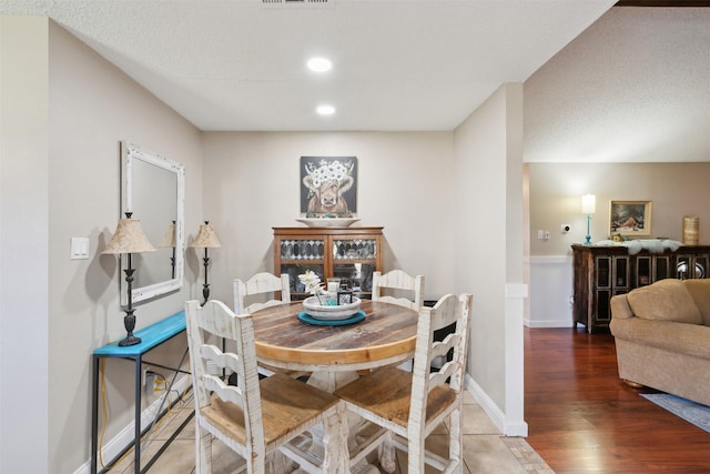 dining room with hardwood / wood-style floors and a textured ceiling