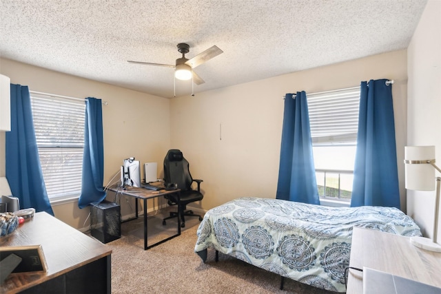 bedroom featuring ceiling fan, light colored carpet, and a textured ceiling