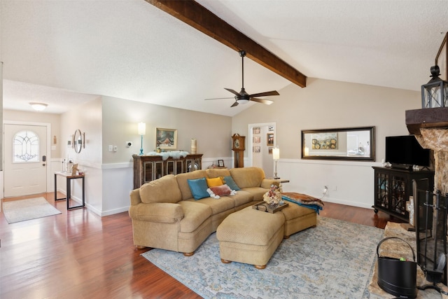 living room with a textured ceiling, vaulted ceiling with beams, hardwood / wood-style flooring, and ceiling fan