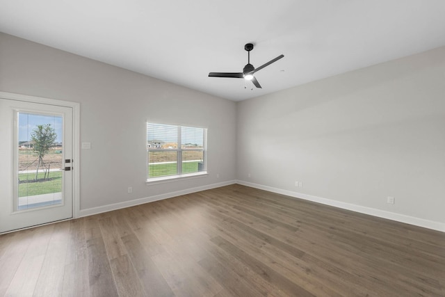 spare room with ceiling fan, plenty of natural light, and dark hardwood / wood-style floors