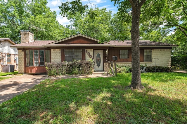 single story home with cooling unit and a front yard