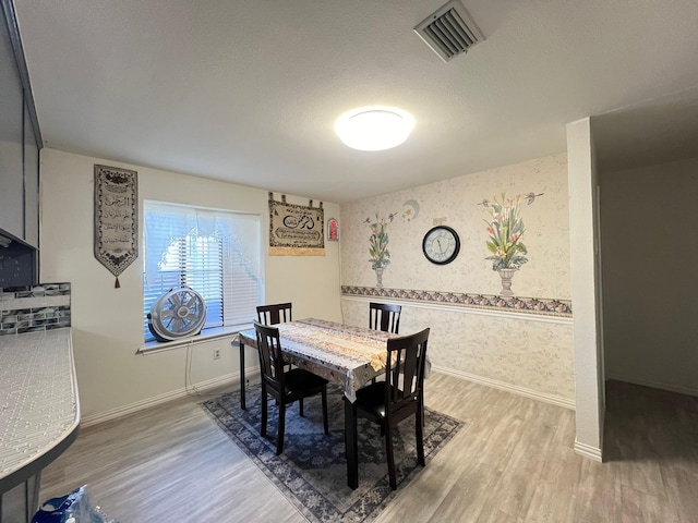 dining room with hardwood / wood-style flooring and a textured ceiling