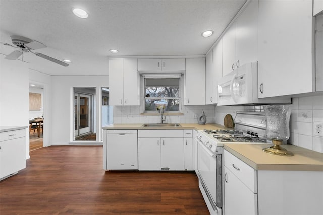 kitchen with white cabinetry, sink, dark wood-type flooring, white appliances, and decorative backsplash