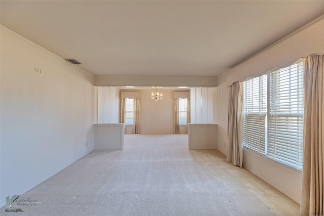 carpeted spare room with a notable chandelier and ornamental molding