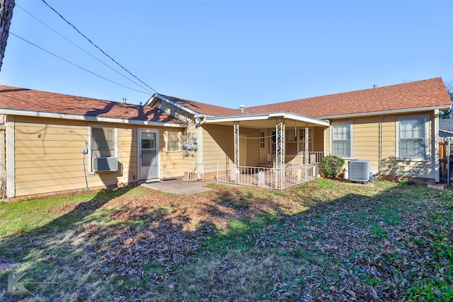 rear view of house featuring a lawn, cooling unit, and central air condition unit