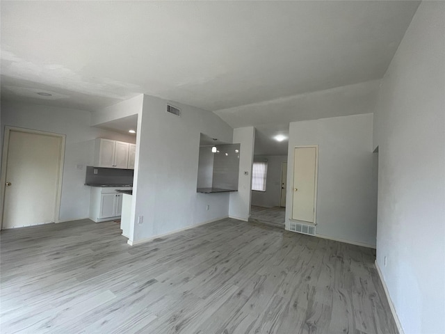 unfurnished living room with light hardwood / wood-style flooring and lofted ceiling