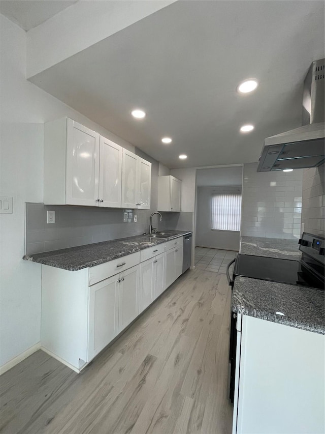 kitchen featuring decorative backsplash, white cabinetry, extractor fan, and range