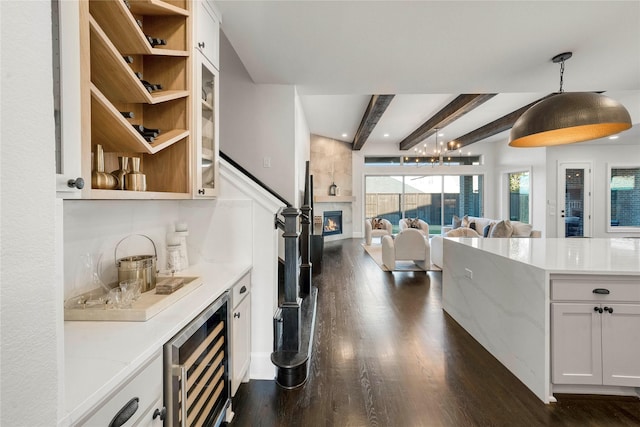 kitchen featuring wine cooler, white cabinets, hanging light fixtures, dark wood-type flooring, and beam ceiling