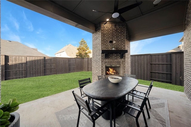 view of patio with an outdoor brick fireplace and ceiling fan