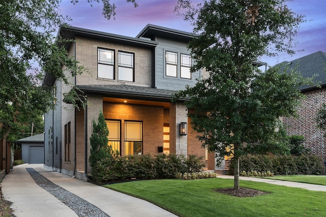 view of front of house with a garage, an outdoor structure, and a lawn