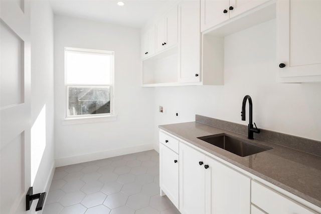 kitchen featuring white cabinets, light tile patterned flooring, and sink