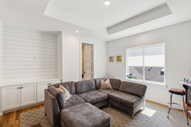 living room featuring a raised ceiling and dark hardwood / wood-style floors