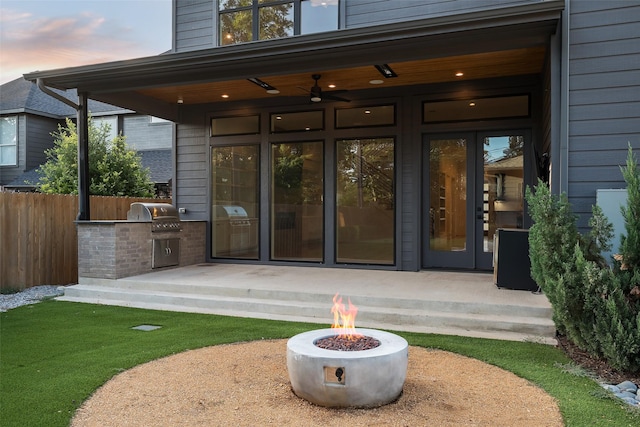 exterior entry at dusk featuring a patio area and exterior kitchen