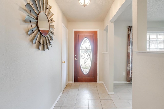 foyer featuring a wealth of natural light, a textured ceiling, and light tile patterned floors