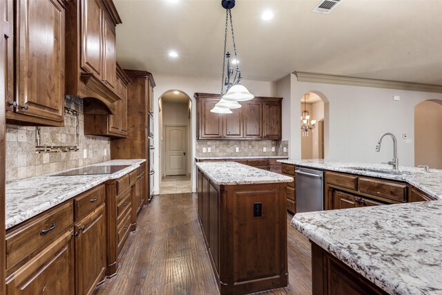 kitchen with dishwasher, sink, black electric cooktop, decorative light fixtures, and a kitchen island