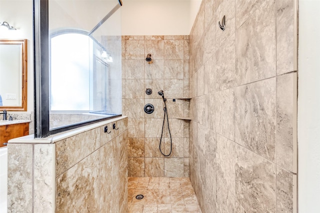 bathroom featuring tiled shower and vanity