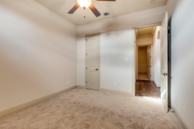 unfurnished bedroom with light colored carpet and ceiling fan