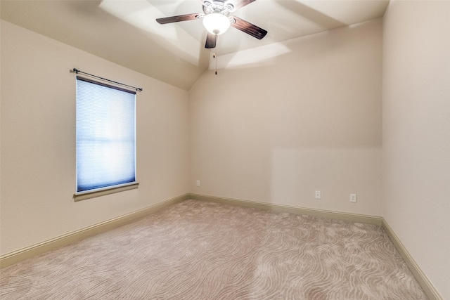 carpeted spare room featuring ceiling fan and vaulted ceiling