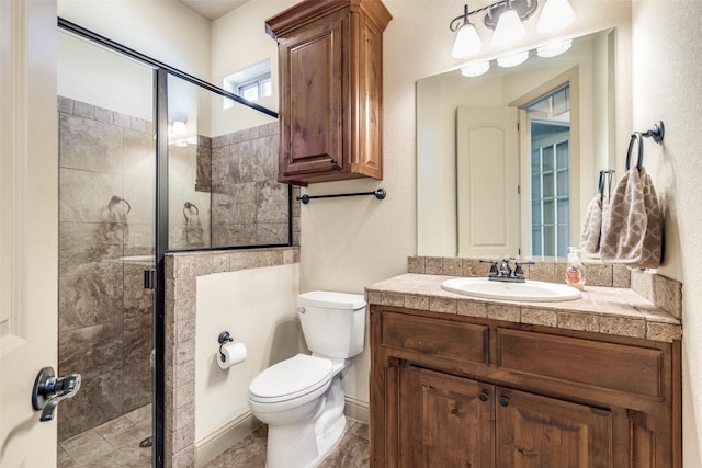 bathroom featuring vanity, toilet, and a shower with door