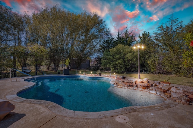 pool at dusk with a patio