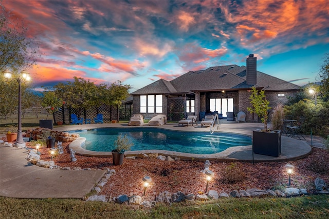 pool at dusk with a patio