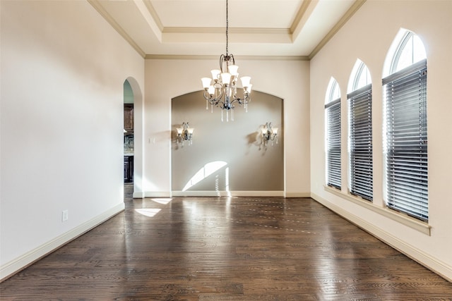 unfurnished room featuring a chandelier, dark hardwood / wood-style flooring, a tray ceiling, and ornamental molding